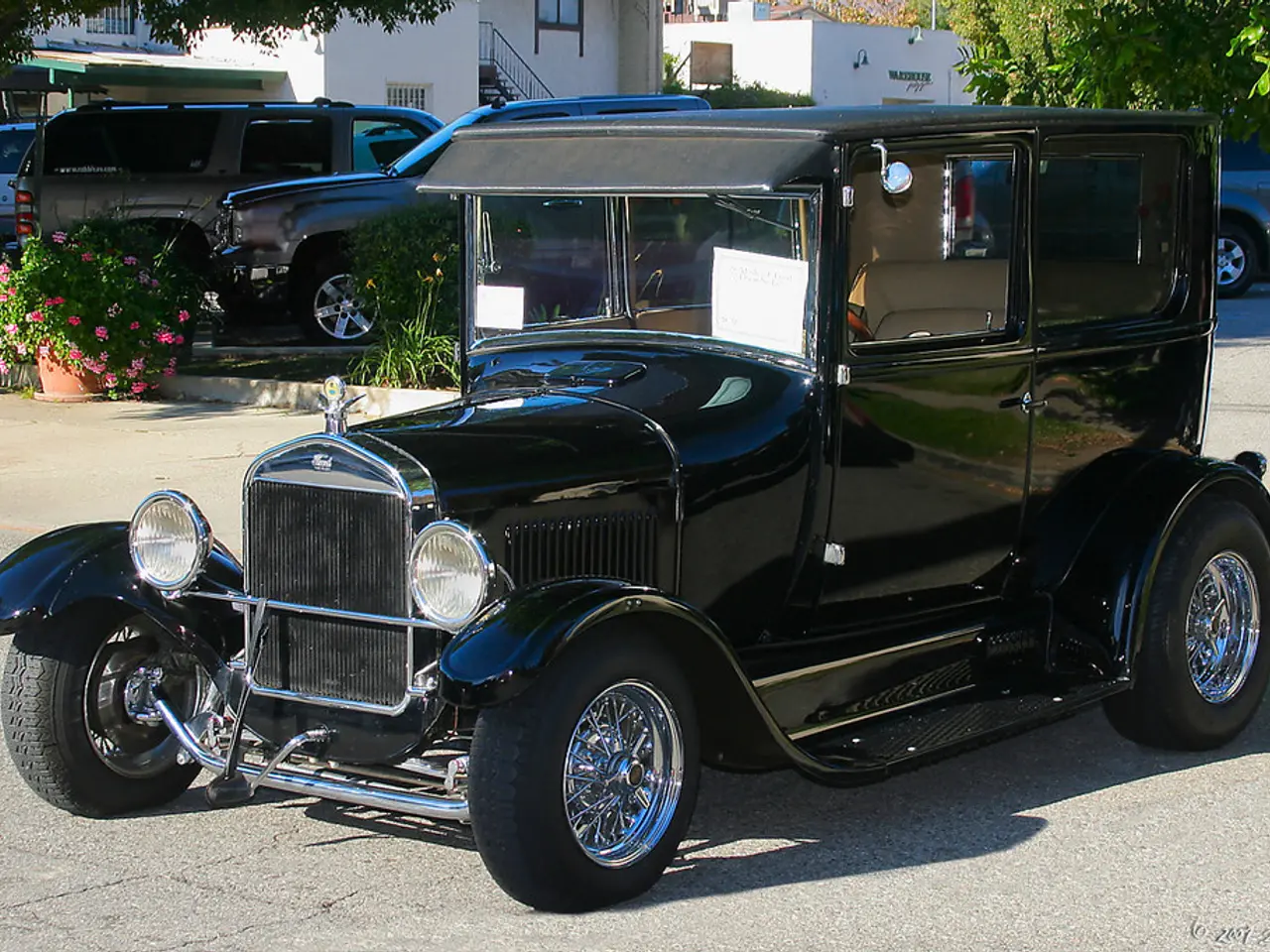 In this image there is an antique car on the road surface, behind the antique car there are...