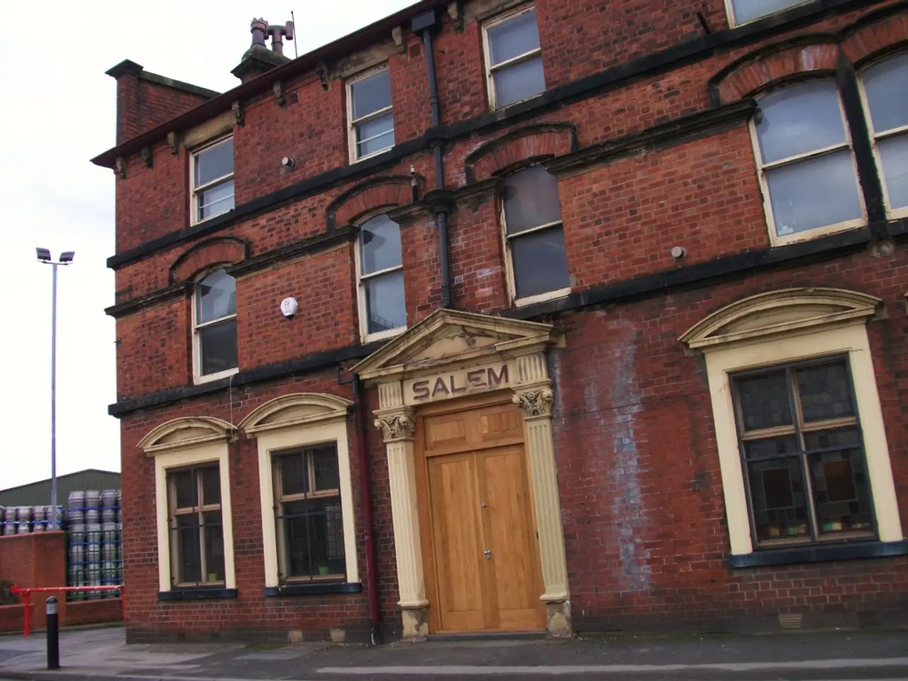 As we can see in the image there are buildings, fence, light, windows, door and sky.