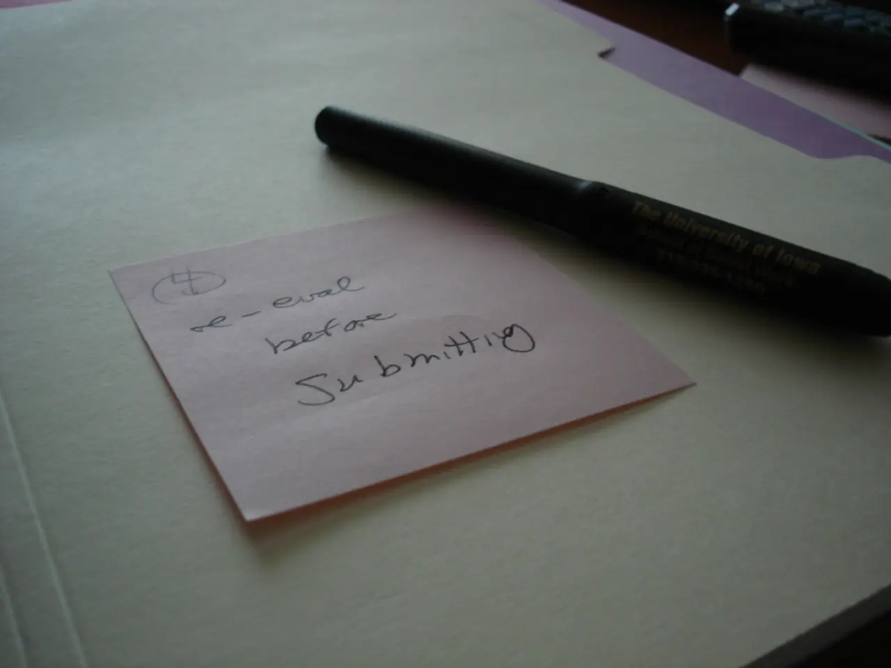 In this image we can see a paper note with some text written on it, and a pen beside it, are placed...