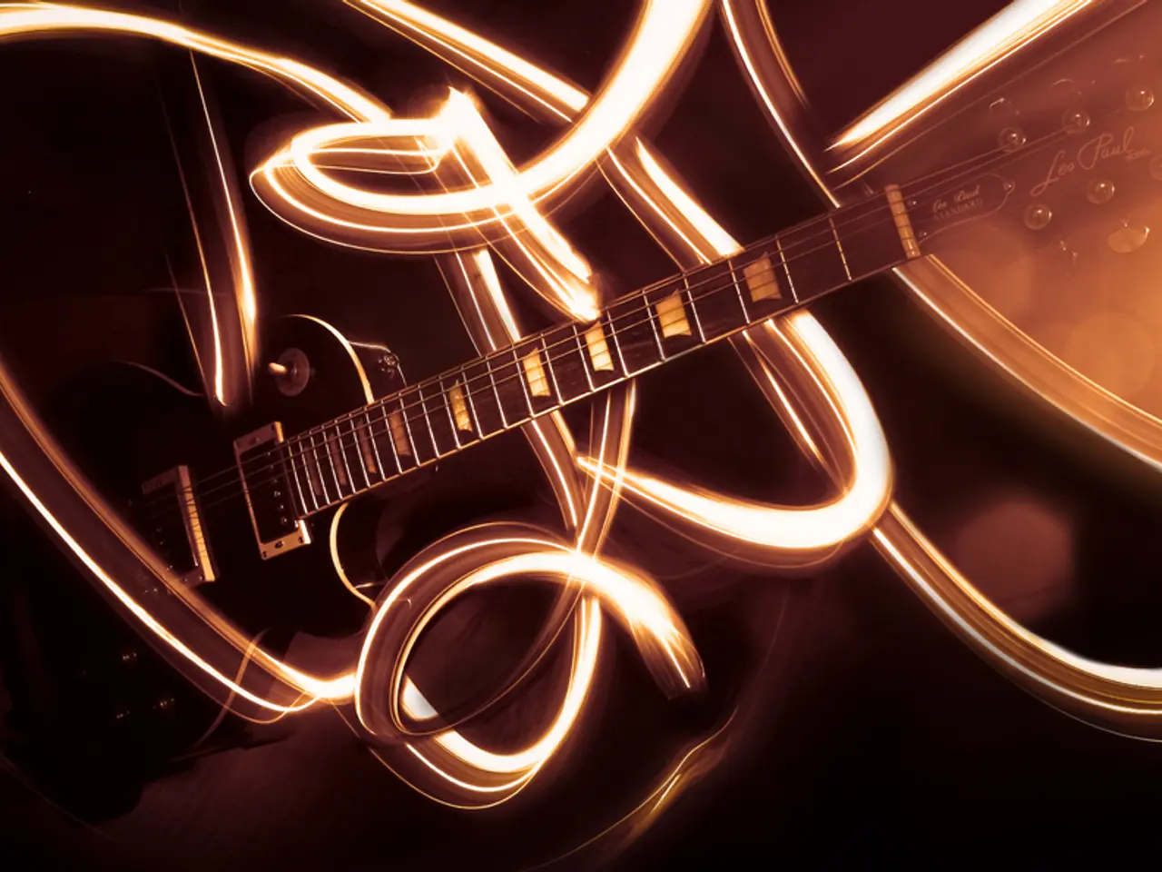 In this image there is a guitar and some graffiti around.