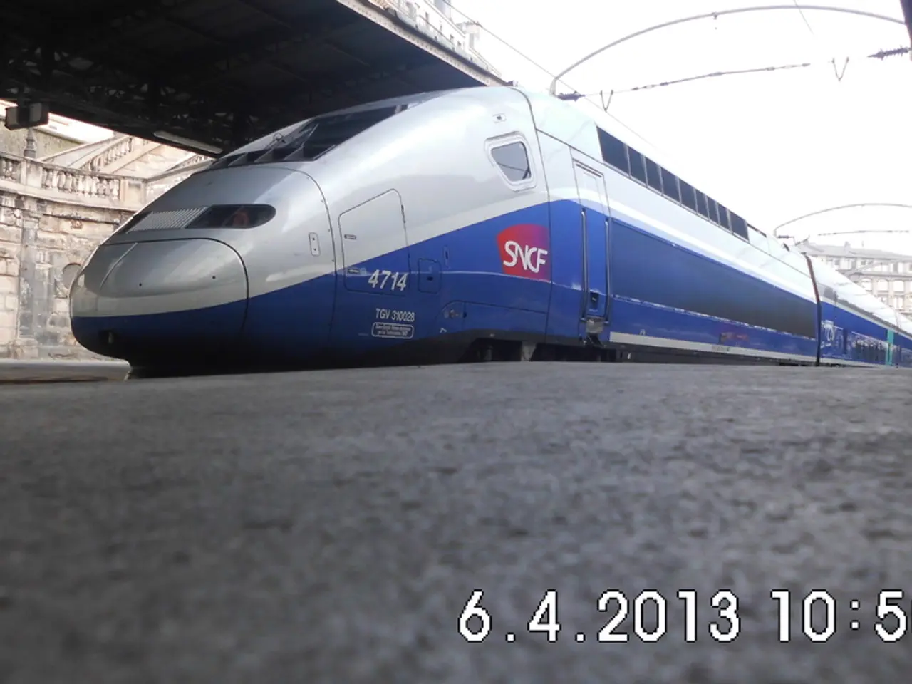 In this image in the middle there is a train. At the bottom there is platform and text. On the left...