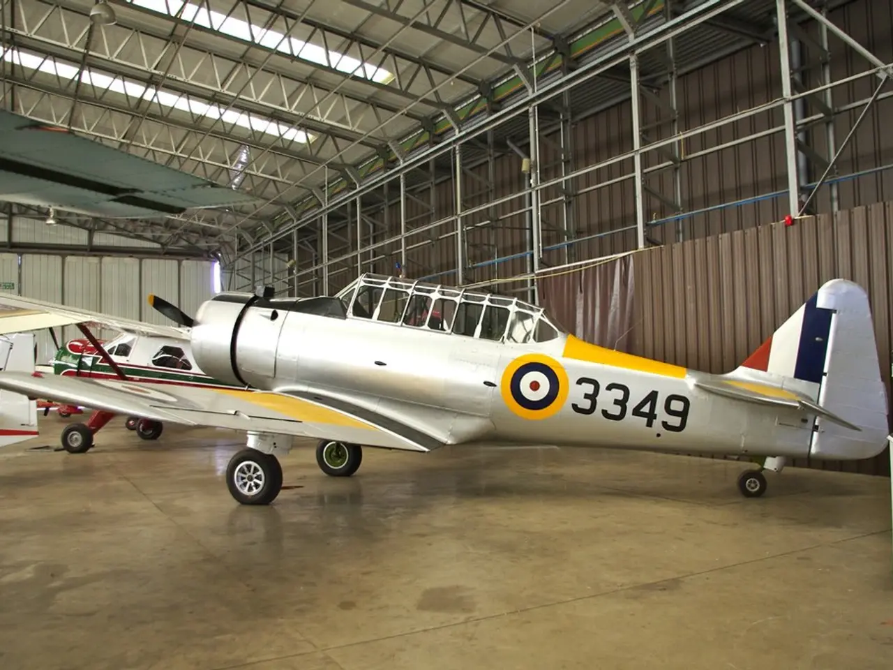 In this picture we can see there are aircrafts on the floor. Behind the aircraft's there is a sign...