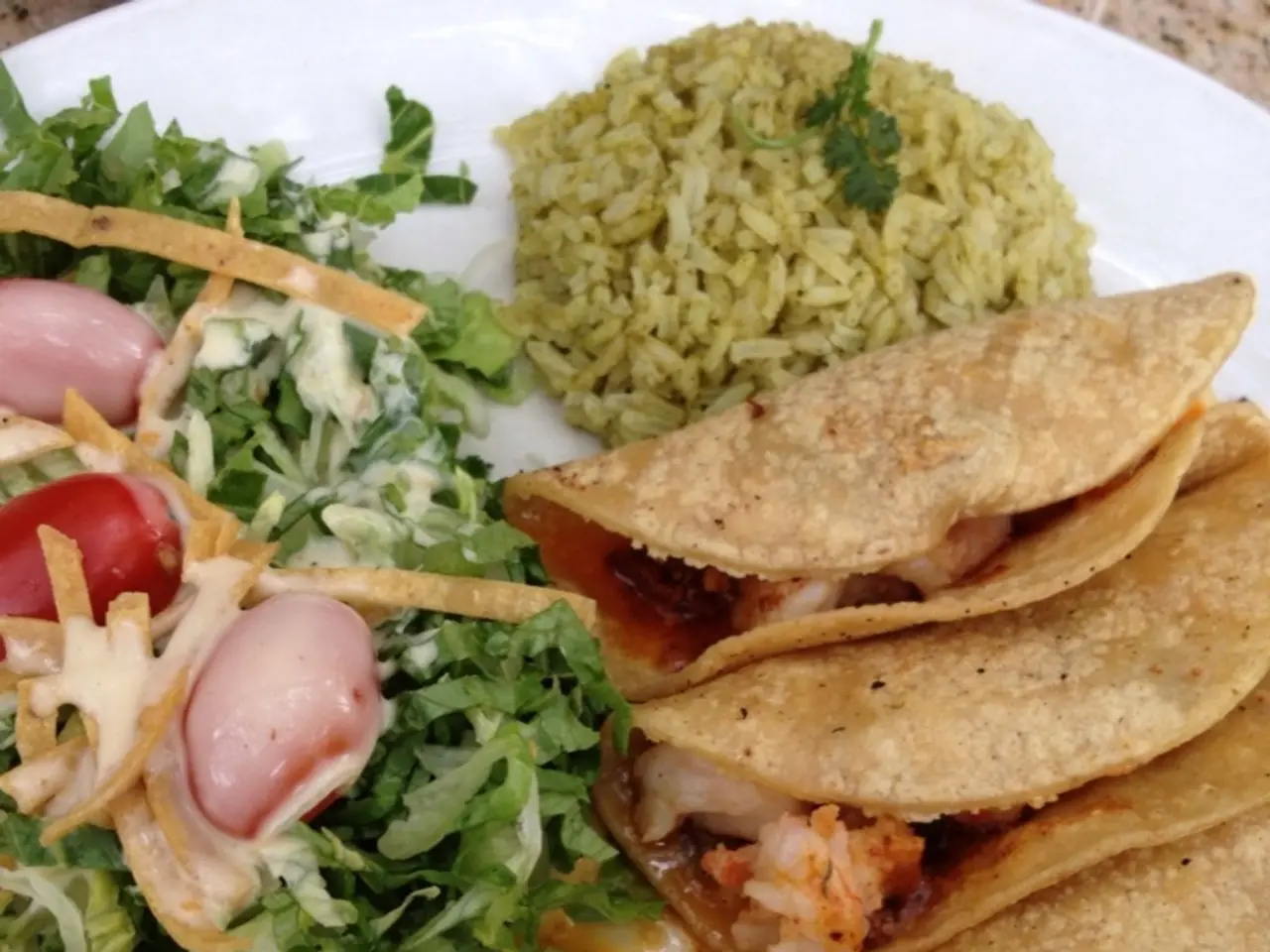 This is a picture of food were we can see some rice, vegetable and snacks is decorated on white...