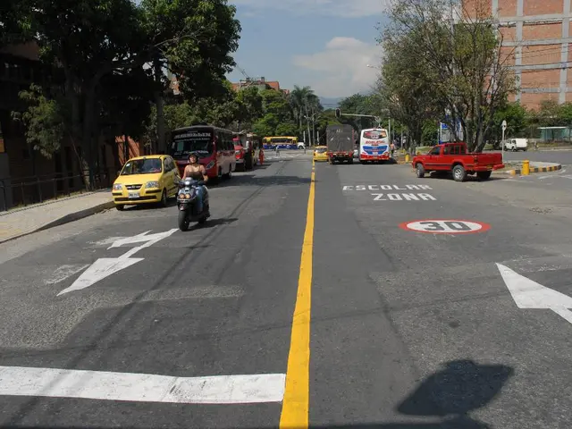 This picture shows a few buildings and trees and we see few vehicles moving on the road and we see...