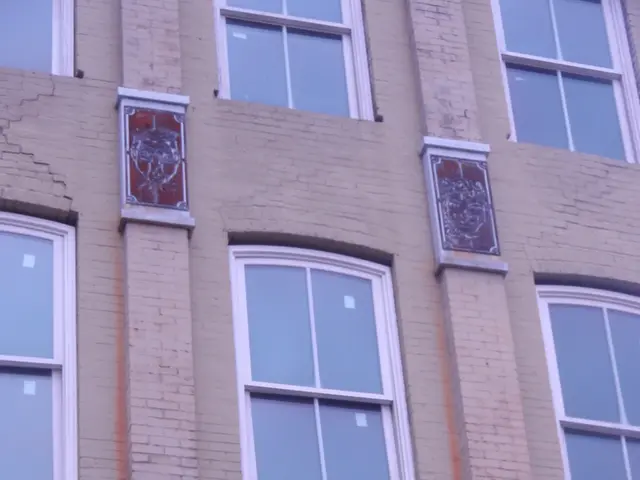 In this image there is a building with the glass windows.