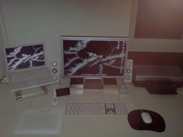 In the image there is a monitor, laptop, keyboard, mouse and other gadgets.